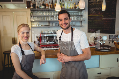 Portrait of confident baristas standing at counter