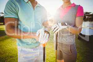 Midsection of golfer couple