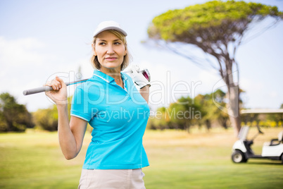 Mature woman carrying golf club