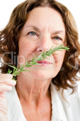 Portrait of mature woman smelling rosemary