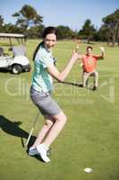 Portrait of happy golfer woman clenching fist