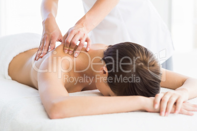 Naked woman receiving back massage