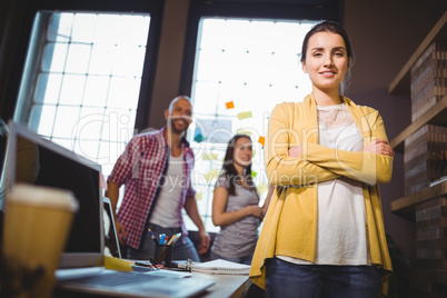 Confident businesswoman with colleagues in background