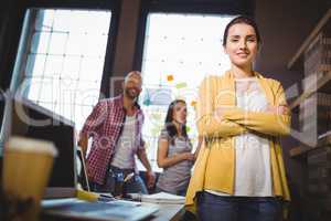 Confident businesswoman with colleagues in background