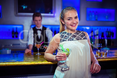 Portrait of smiling woman standing against bartender