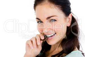 Close-up portrait of smiling woman eating chocolate bar