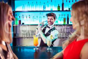 Barkeeper preparing cocktail for female customers