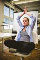 Businesswoman meditating in meeting room
