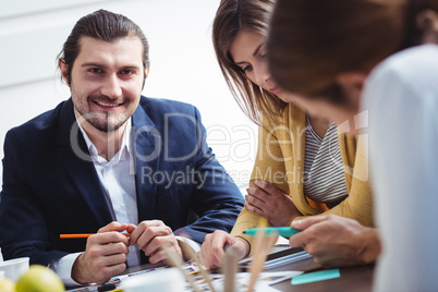 Portrait of smiling male photo editor with colleagues