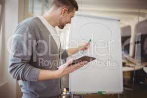 Businessman holding digital tablet while giving presentation in