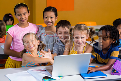 Smiling multi ethnic children using laptop