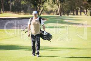 Sportsman walking with his golf bag