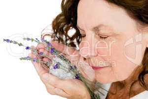 Close-up of smiling mature woman smelling flowers