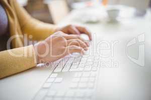 Cropped image of businesswoman typing on keyboard