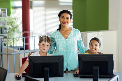 Teacher with children during computer class