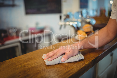 Close-up of waiter cleaning counter at cafe