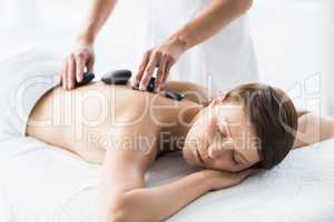 Relaxed woman receiving hot stone massage