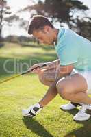 Golfer man placing golf ball on tee