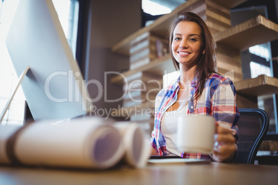 Confident businesswoman sitting at computer desk