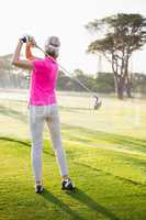 Rear view of sportswoman playing golf