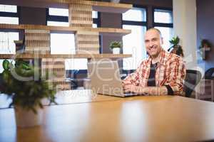 Confident businessman using laptop at desk