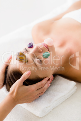Woman receiving facial stone massage from masseur
