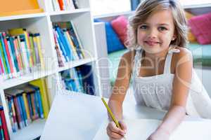 Smiling girl studying in school library