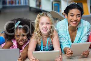 Teacher with girls using digital tablets in library