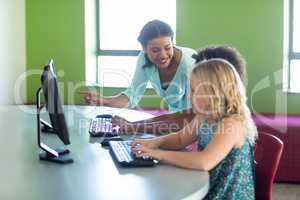 Female teacher teaching computer with children