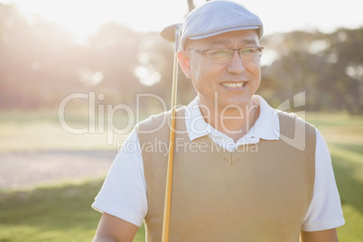 Sportsman holding his golf club and looking away