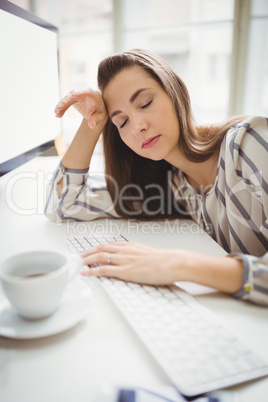 Businesswoman taking nap while working in creative office