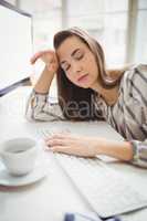 Businesswoman taking nap while working in creative office