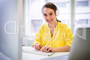 Portrait of happy executive while typing on keyboard at office