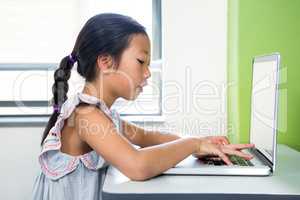 Girl using laptop in classroom