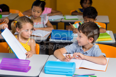 Girl showing book to classmate