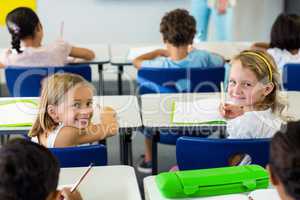 Girls sitting with classmates in classroom
