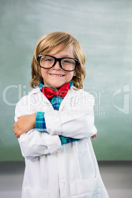 Smiling boy dressed as scientist standing in classroom