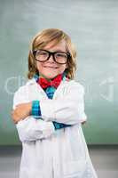 Smiling boy dressed as scientist standing in classroom