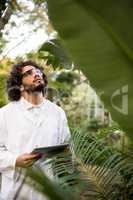 Scientist inspecting plants at greenhouse