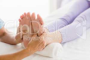 Cropped image of masseur giving foot massage to woman