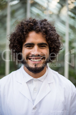 Confident male scientist against greenhouse