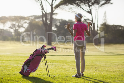 Rear view of mature woman holding golf club