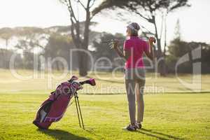 Rear view of mature woman holding golf club