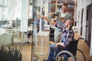 Businessman assisting handicap colleague in creative office