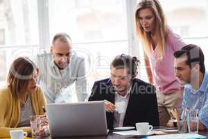 Business people using laptop during meeting