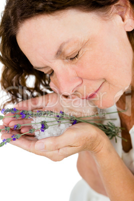 Smiling mature woman smelling flowers