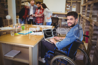 Confident disabled businessman using laptop at desk