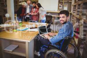 Confident disabled businessman using laptop at desk