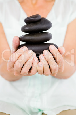Midsection of woman holding pebbles