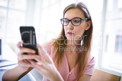 Attractive graphic designer using phone